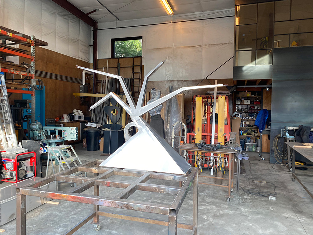 fabrication of a stainless sculpture on a table in a art studio