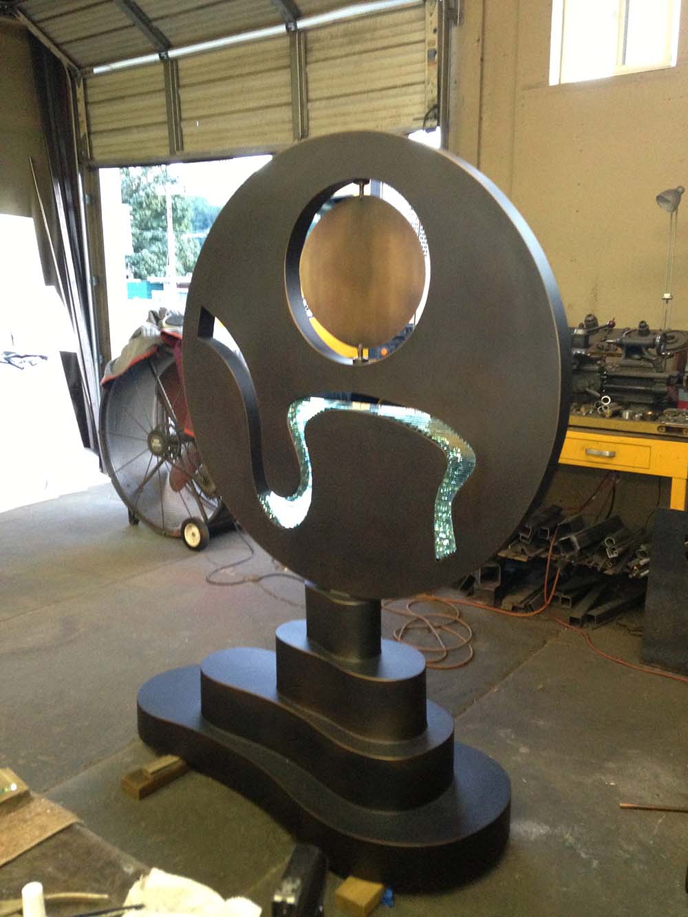 round bronze sculpture large in a studio with glass inlay