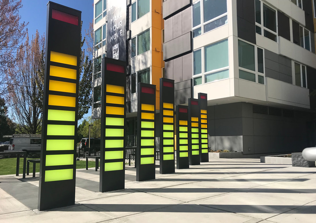 plaza modern sculpture of 7 columns with red yellow and green acrylic panels