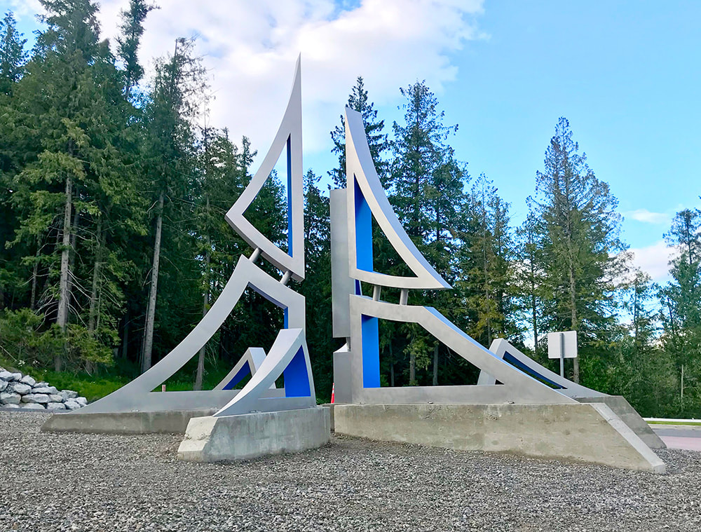 roundabout sculpture depicting mountains and stars in stainless steel public art